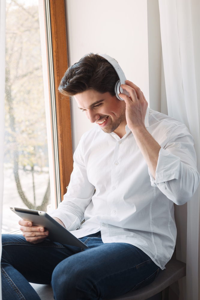 Man reading Ebook on a tablet computer and listening Audiobook